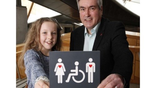 Girl and man with accessible toilets sign