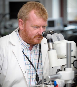 Researcher using a microscope