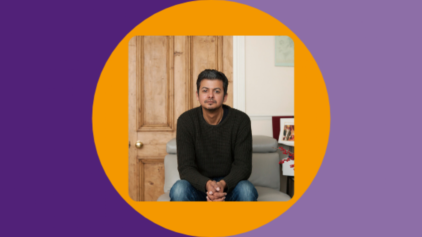 Omar sitting in a room looking at camera