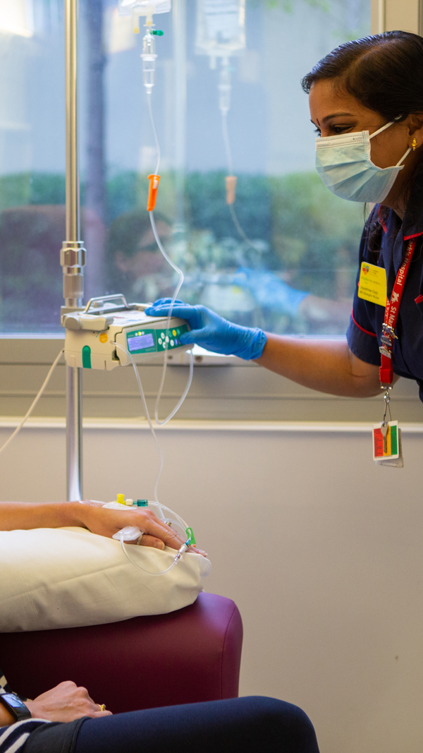 Woman having infusion chatting with nurse